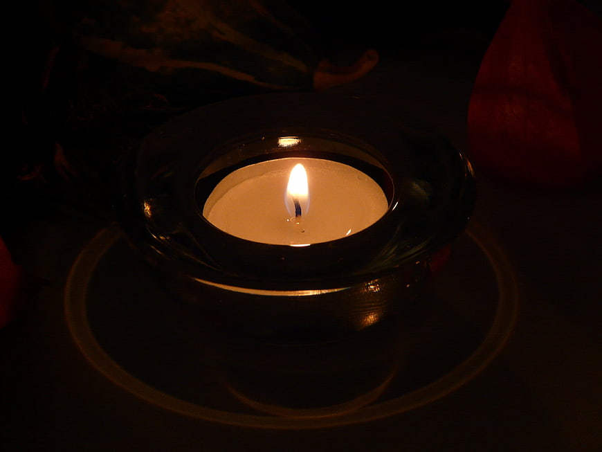Glowing Tea Light Candle in Glass Holder at Night