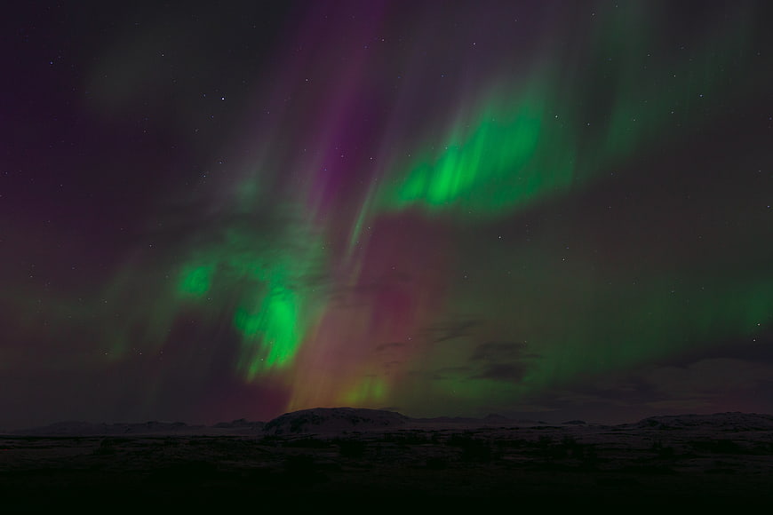 Vibrant Aurora Borealis Over Snowy Arctic Landscape at Night