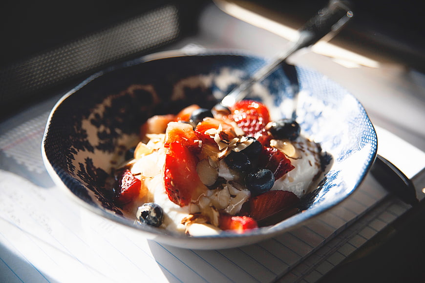 Healthy yogurt bowl with berries and almonds in sunlight