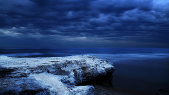 Dramatic Blue Coastal Landscape with Rocky Shore and Stormy Sky