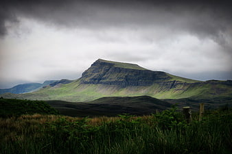 Dramatic Green Mountain Landscape Under Stormy Clouds