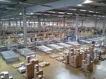 Interior of a large industrial warehouse with conveyor belts and stacked boxes