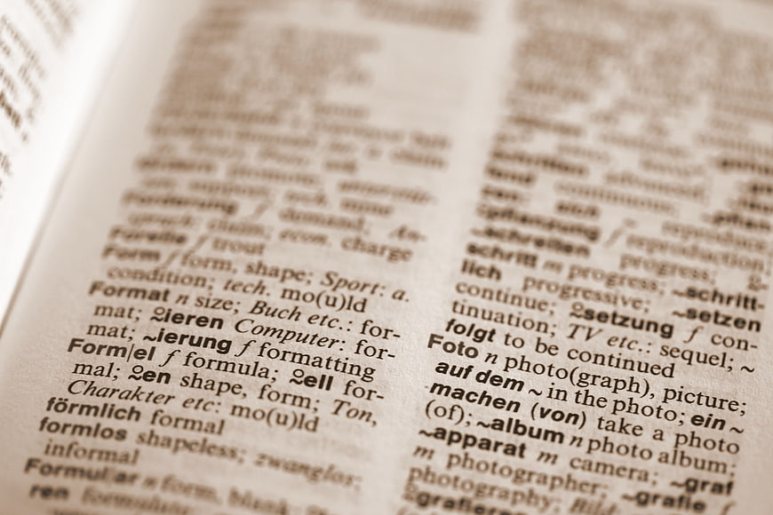 Close-up of open dictionary page with German and English definitions