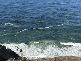 High angle view of ocean waves crashing on rocky coast
