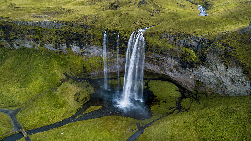 Aerial View of Majestic Waterfall in Lush Green Icelandic Landscape