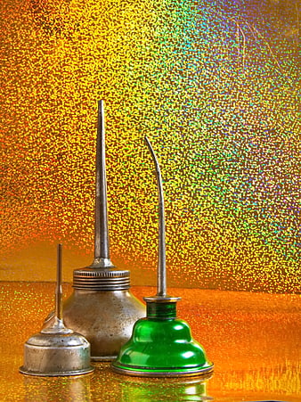 Vintage metal oil cans on glittering gold background