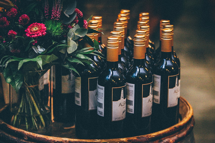 Wine bottles and flowers on wooden barrel