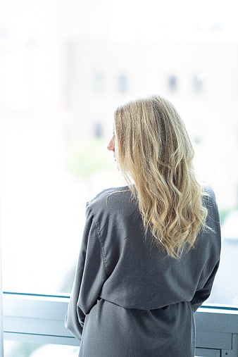 Blonde Woman in Grey Robe Looking Out Window