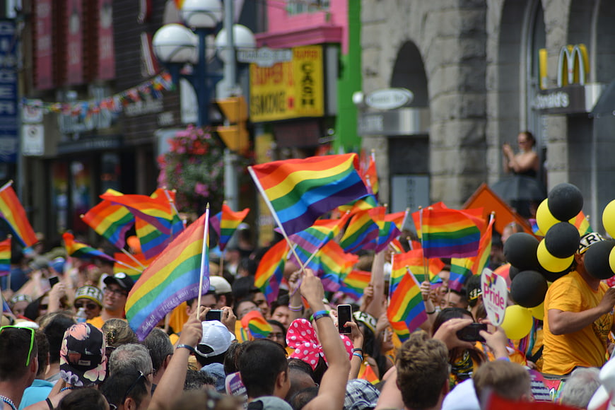 Crowd waving rainbow flags at Pride parade