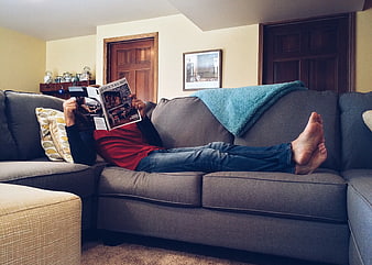 Woman Relaxing on Sofa Reading Magazine