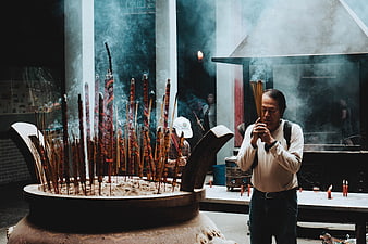 Man Praying with Incense at Temple Altar