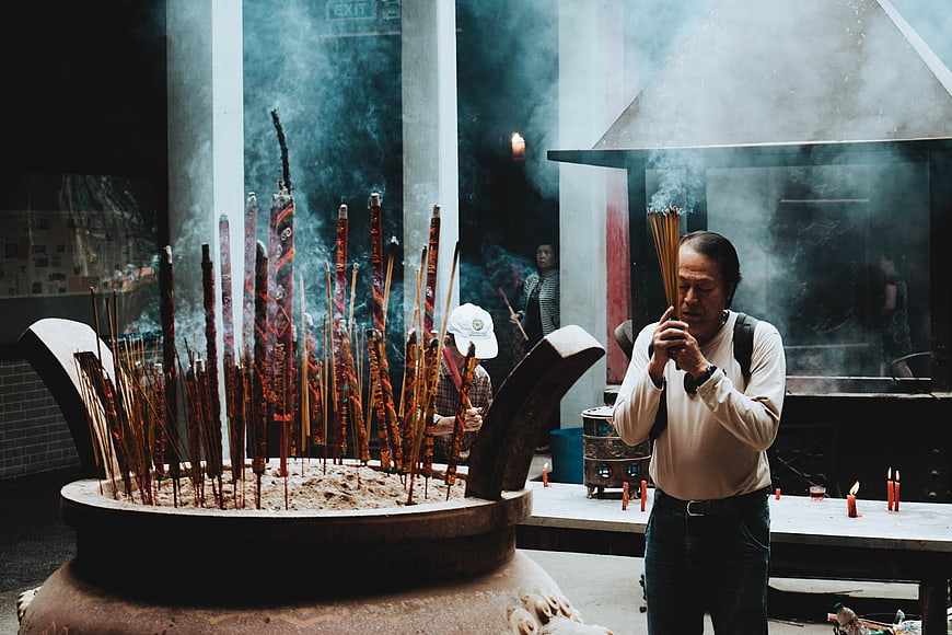Man Praying with Incense at Temple Altar