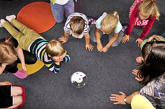 Top-Down View of Kindergarten Children Playing Group Game on Carpet
