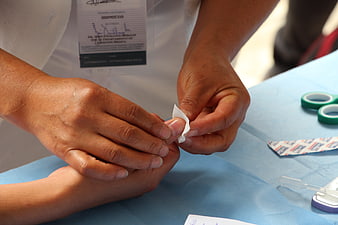 Close-up of nurse applying bandage to patient finger