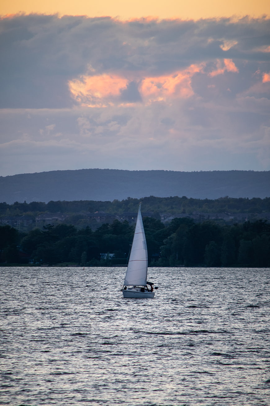 Sailboat on Lake at Sunset with Distant Mountains