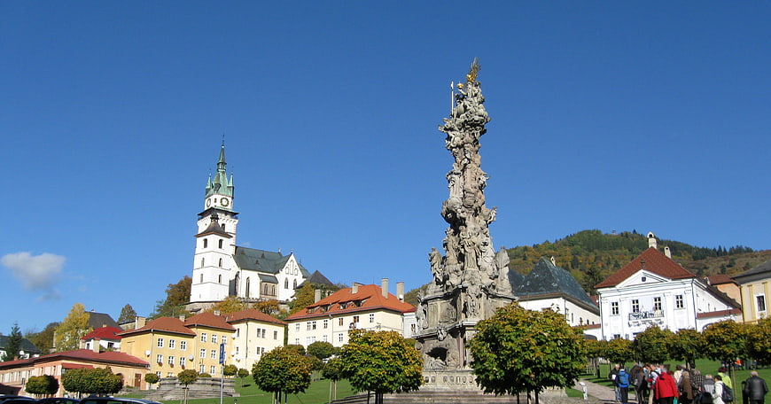 Baroque plague column and church tower in European town square