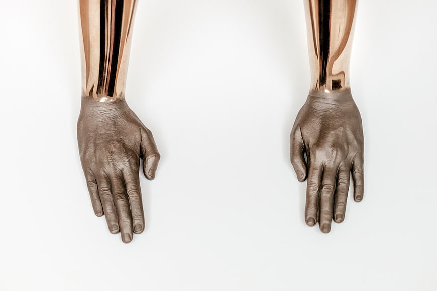 Top view of metallic bronze mannequin hands on white background