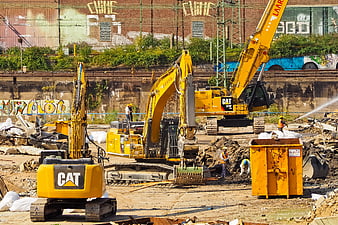 Yellow CAT Excavators Demolishing Building With Workers And Rubble