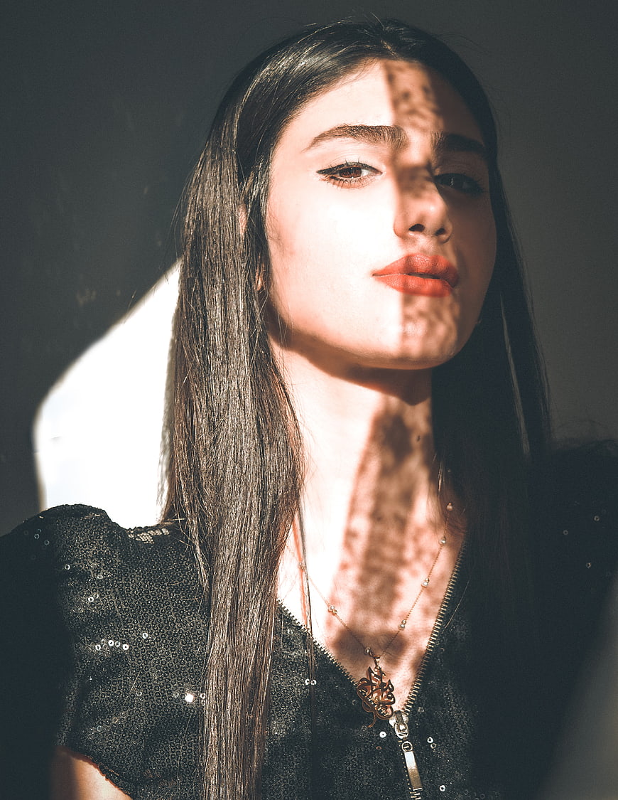 Woman with dramatic shadow patterns on face and neck