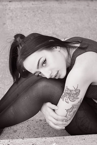 Black and white portrait of woman with tattoos looking up