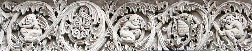 Medieval stone carving with cherubs and acanthus leaves