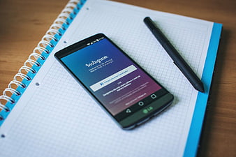 Smartphone with Instagram App on Notebook and Pen