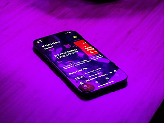 Smartphone displaying podcast app on purple wooden table