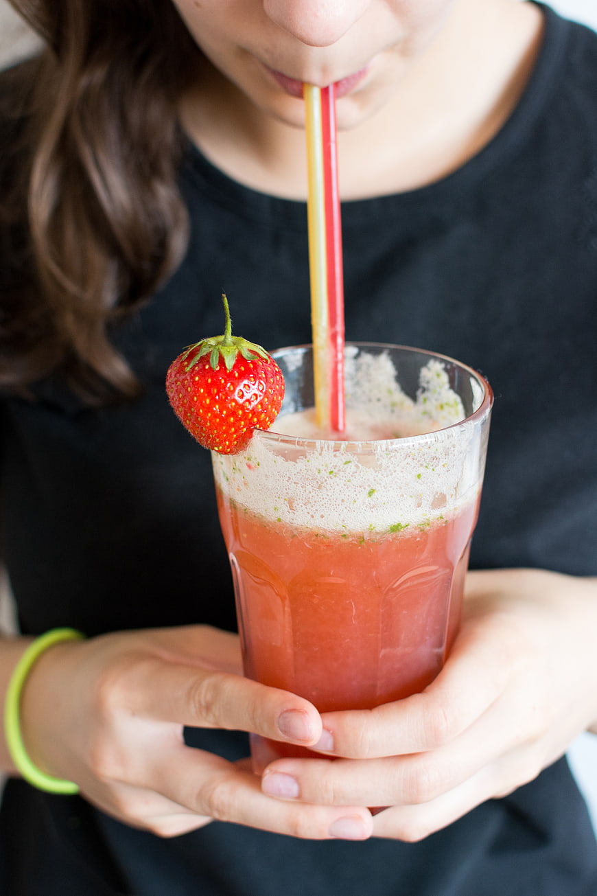 Woman drinking strawberry basil lemonade with straws