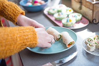 Woman preparing Easter brunch with pinwheels and deviled eggs