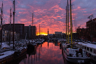 Dramatic pink sunset over Groningen harbor with boats