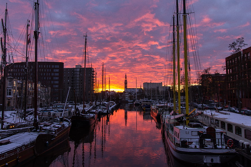 Dramatic pink sunset over Groningen harbor with boats