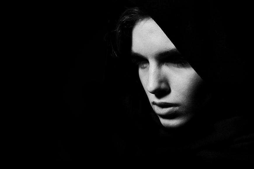 Dramatic black and white portrait of a woman in shadow