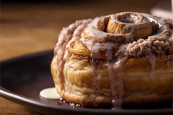 Close-up of Glazed Cinnamon Roll with Crumb Topping