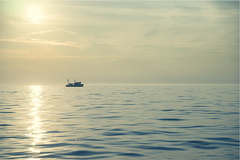 Lone Fishing Boat on Calm Sea at Golden Hour