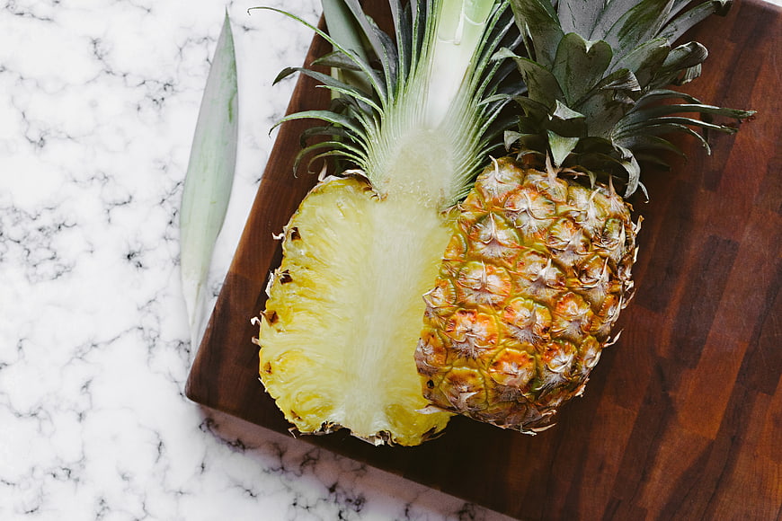 Fresh Halved Pineapple on Wooden Board