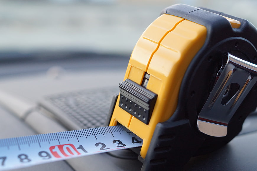 Yellow Tape Measure Close-Up On Car Dashboard