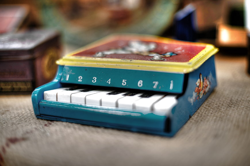 Vintage Blue Tin Toy Piano on Textured Surface