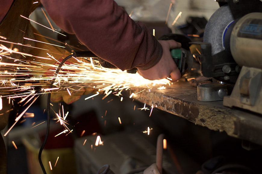Close-up of metal grinding sparks flying in workshop
