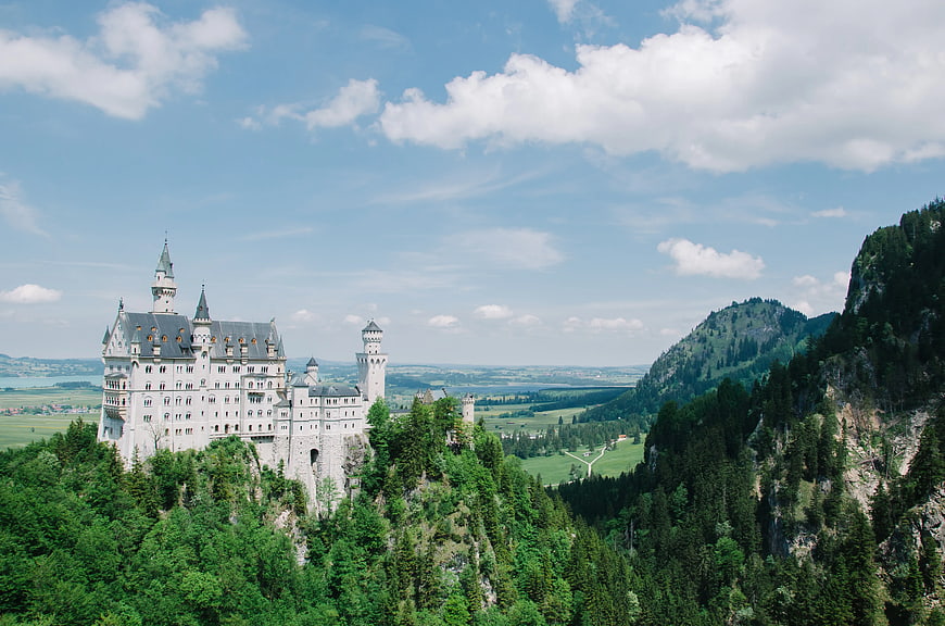 Neuschwanstein Castle on Green Hilltop with Blue Sky