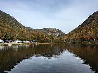 Autumn landscape with lake, mountains, and parking lot