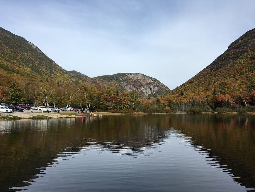 Autumn landscape with lake, mountains, and parking lot