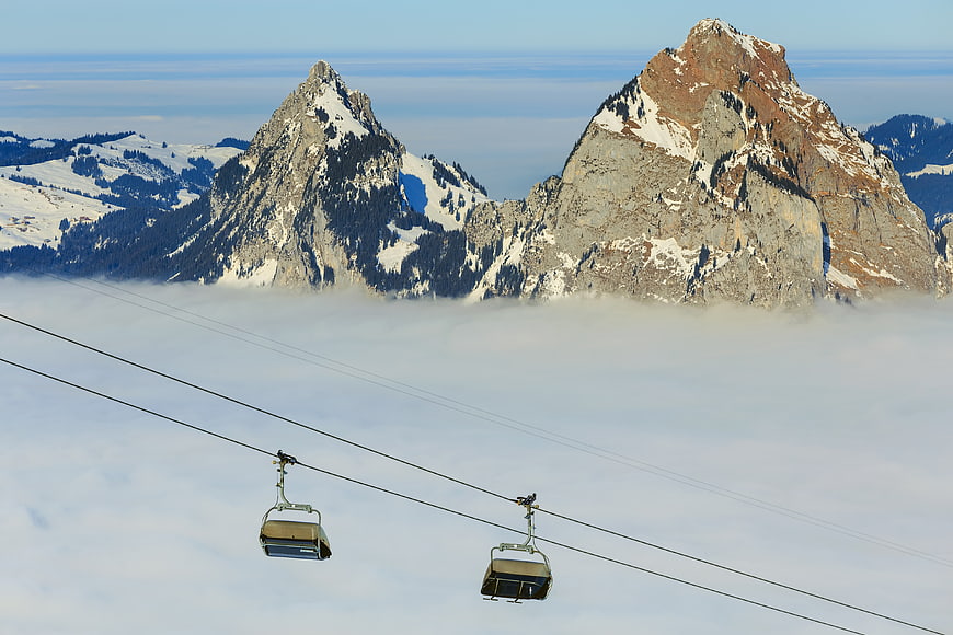 Ski Lift Chairs Above Sea of Fog with Mountain Peaks