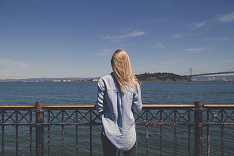 Woman in Denim Looking at Bay Bridge from Pier