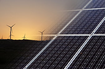 Solar panels and wind turbines at sunset renewable energy