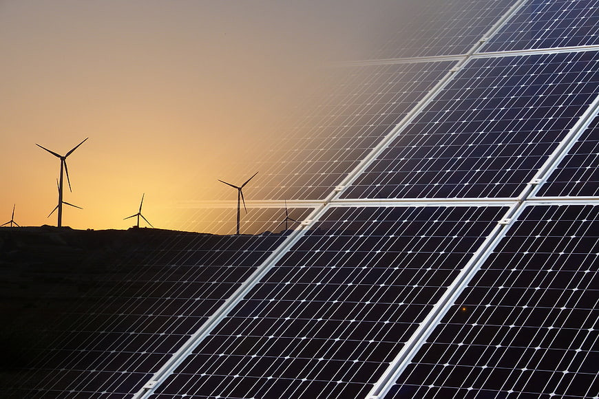 Solar panels and wind turbines at sunset renewable energy