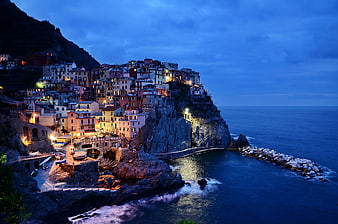 Colorful coastal village on cliff at twilight