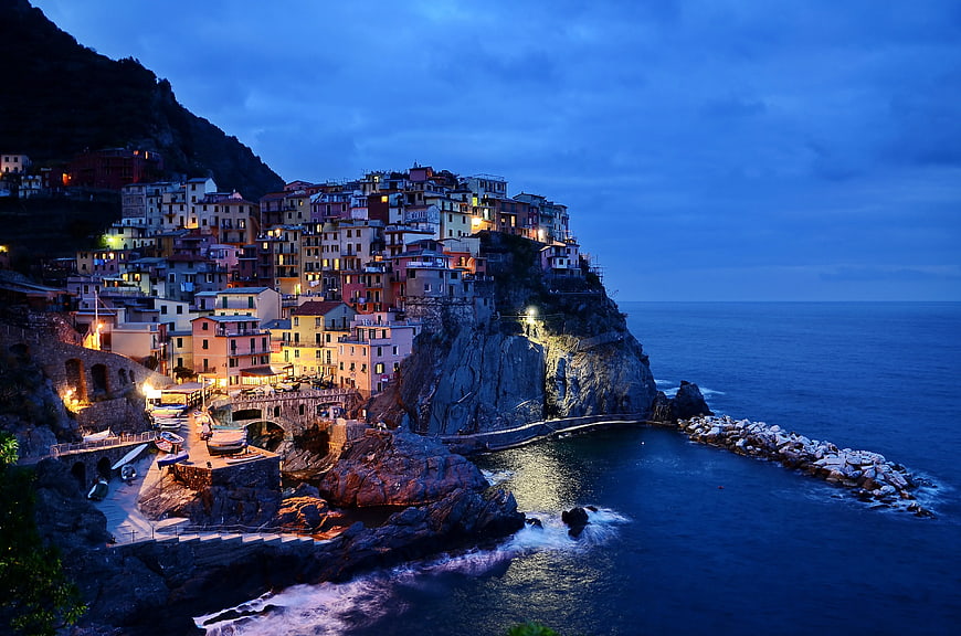 Colorful coastal village on cliff at twilight