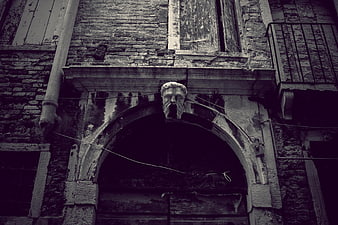 Gothic Stone Mask Sculpture On Weathered Italian Building Facade