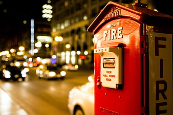 Red Fire Alarm Box on City Street at Night