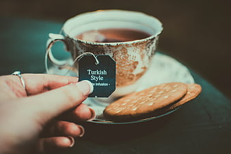 Hand holding Turkish style tea bag tag with biscuits